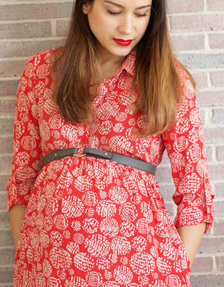 Pregnant brunette wears a red Seraphine maternity dress