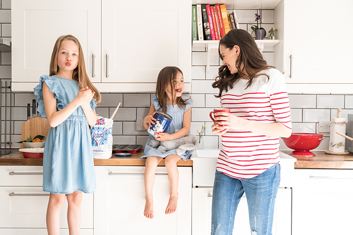 Pregnant mum with daughters in the kitchen